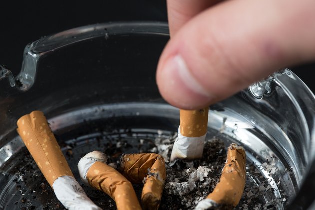 Hand putting out a cigarette in ashtray