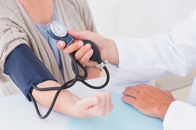 Cropped image of doctor checking patients blood pressure