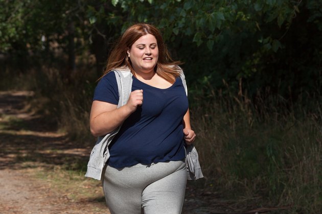 overweight woman running outdoors