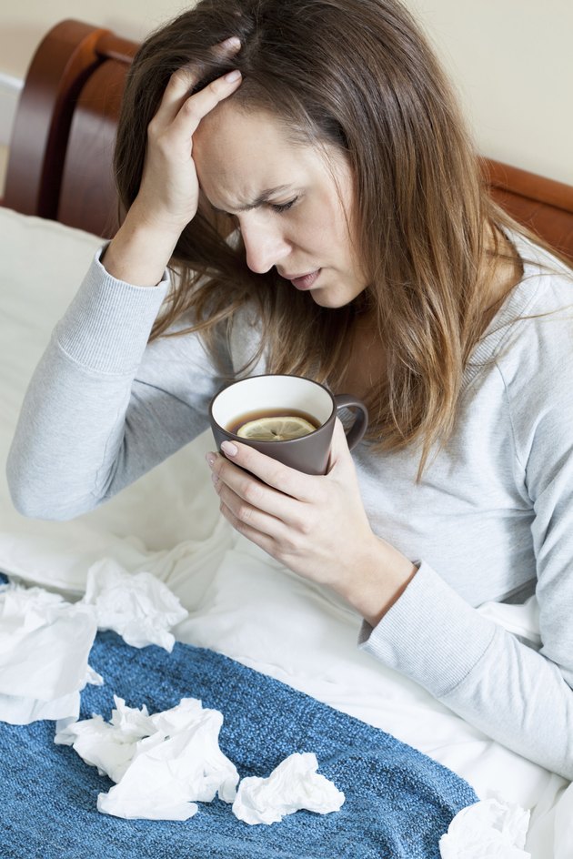 Woman with runny nose in bed