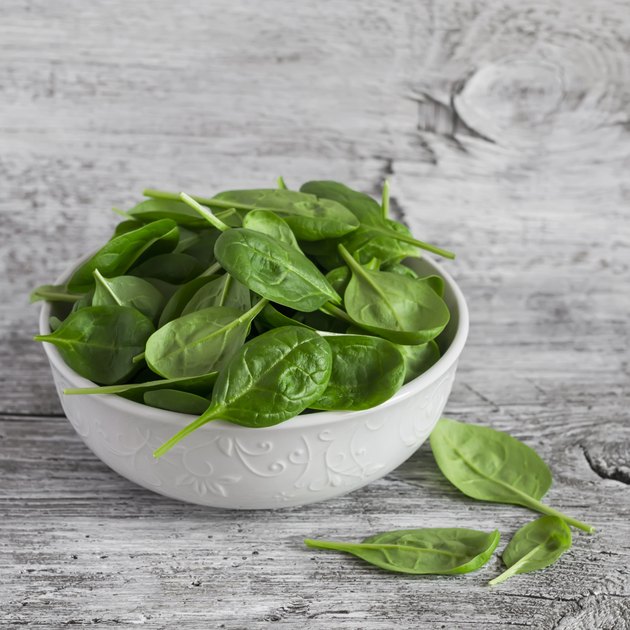 Fresh baby spinach in a white bowl