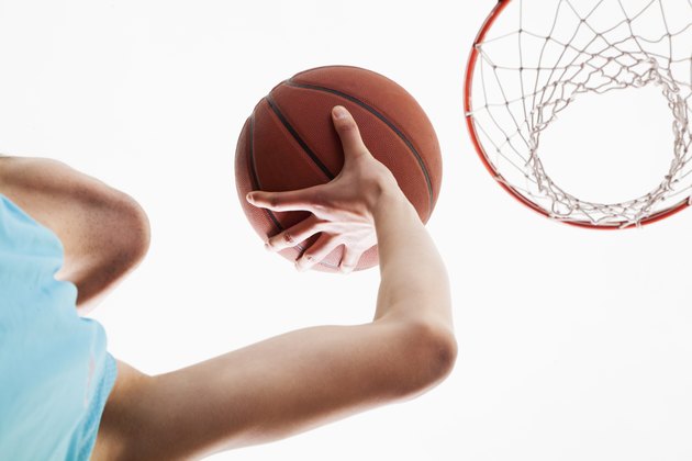 Man attempting to through basketball in to the basket