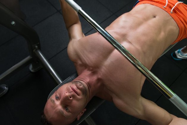 Close-Up Of A Young Man In Gym Exercising Chest On The Bench Press