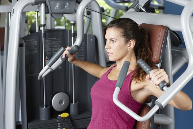 Young woman exercising with machine