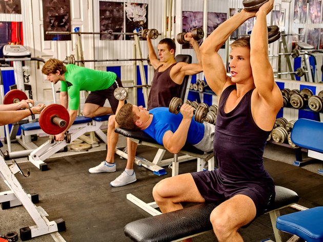 Group of men working his body at gym