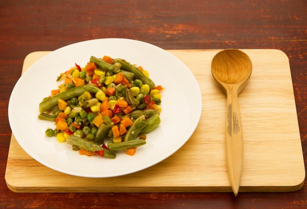 mixed vegetables on white plate on wooden background
