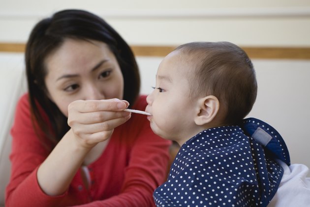 Mother Spoon-feeding Baby Girl