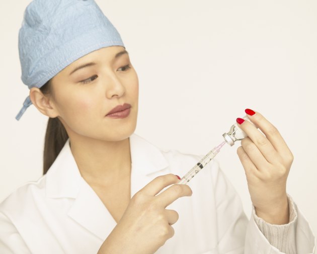 Female doctor using a syringe