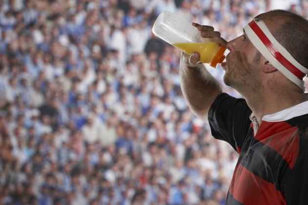 Rugby player drinking from water bottle, side view