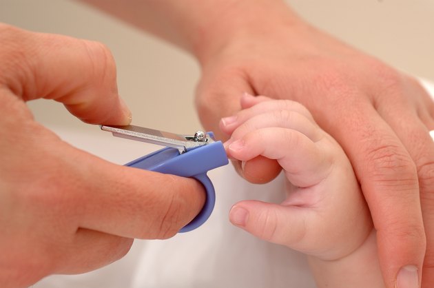 Close up of mum cutting babies nails