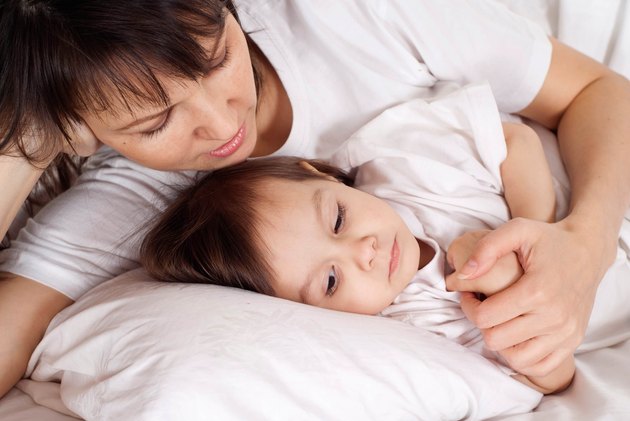 beautiful Caucasian mummy with her daughter lying with a pencil