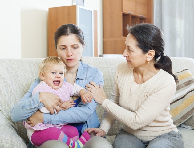 Mature woman comforting daughter with baby a