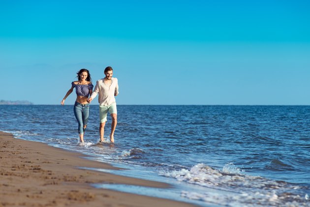 happy young couple running on the beach