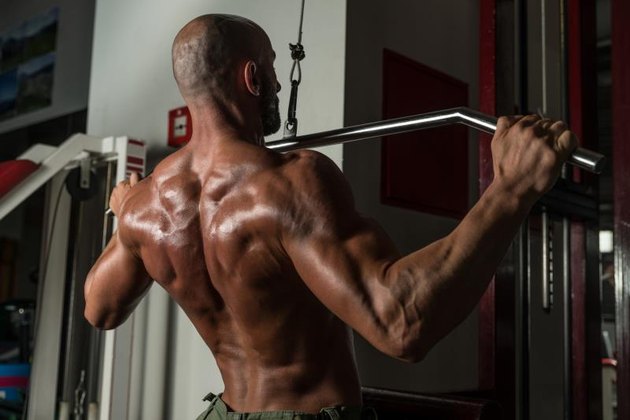 Mature Man Doing Back Exercises In The Gym