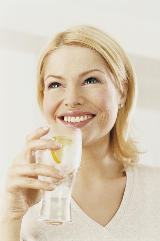 Portrait of a Woman Enjoying a Drink of Water With a Slice of Lemon