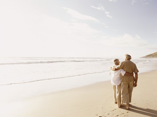 Rear View of a Senior Couple Walking on a Beach With Their Arms Around Each Other