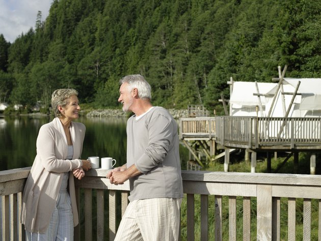 Mature couple relaxing on deck outside tent.