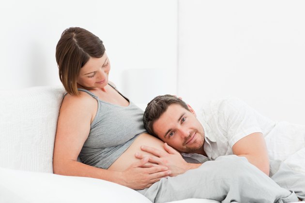Husband listening to his wife's belly