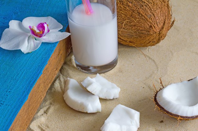Relaxation at the beach with coconuts, coconut milk and orchid