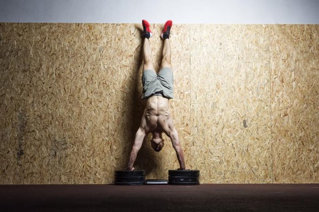 Man performing handstand on the wall