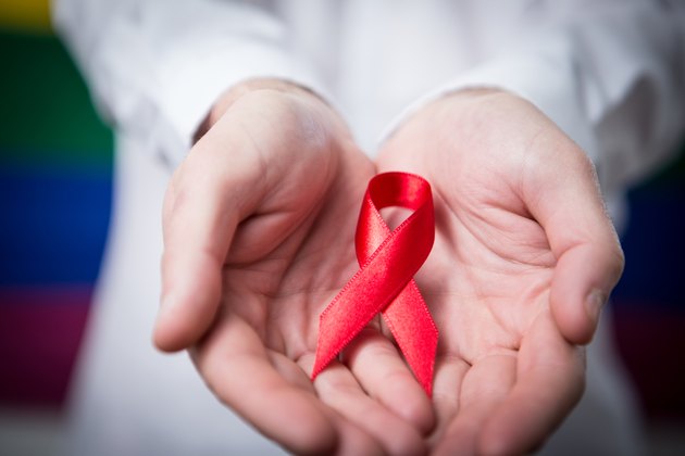 Man holding red aids ribbon