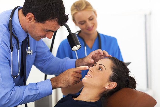 ophthalmologist examining young woman's eye