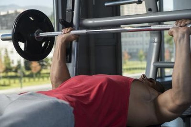 Young Men In Gym Exercising On The Bench Press