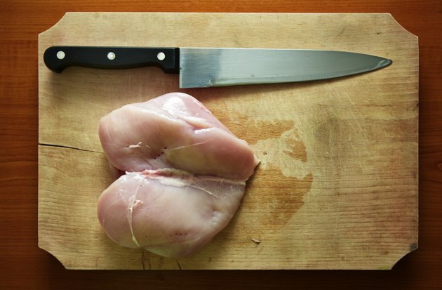 Raw chicken breast with knife