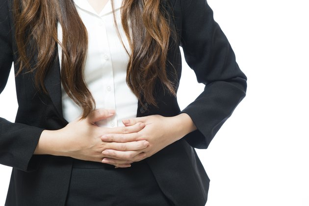 Young businesswoman having back and stomach pain