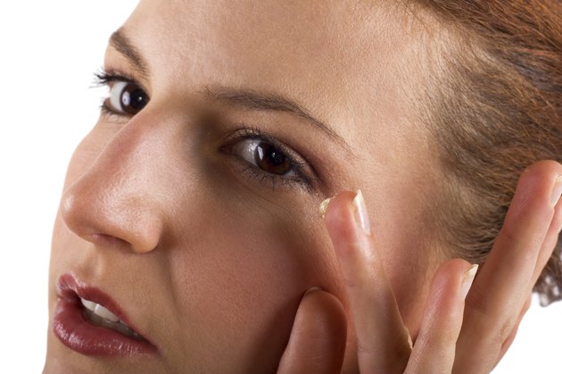 Woman applying anti aging cream ointments