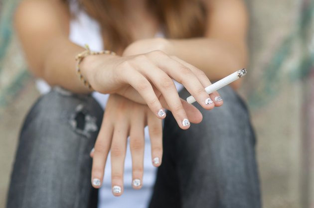 Teenage hands holding cigarette