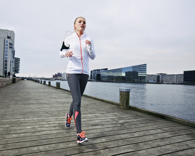 Beautiful young female running on the boardwalk