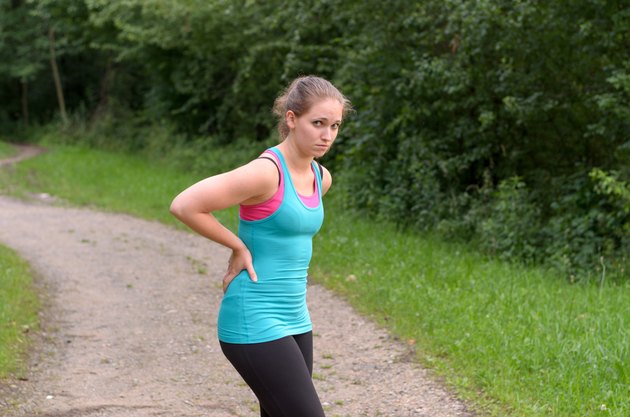 Athletic Woman Having a Back Pain While Exercising