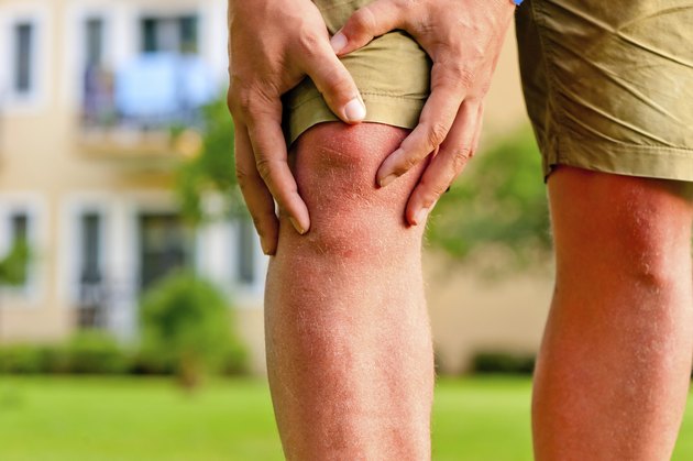man holding hands sore knee