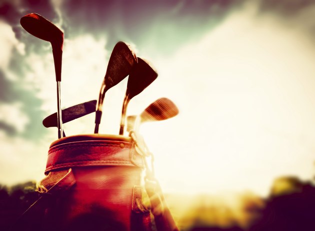 Golf clubs in a leather baggage vintage style at sunset