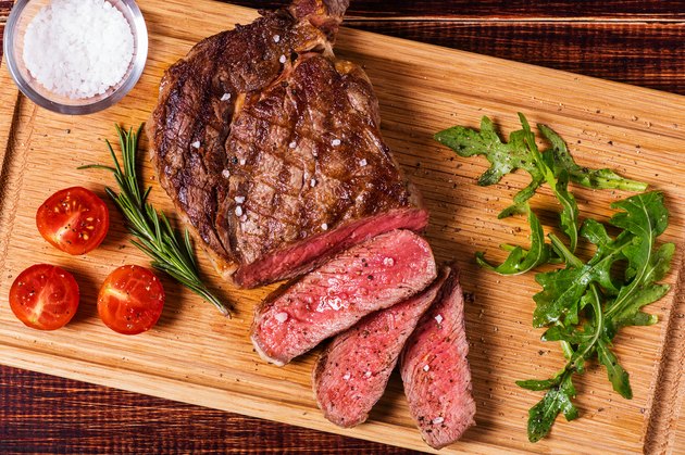 Ribeye steak with arugula and tomatoes.