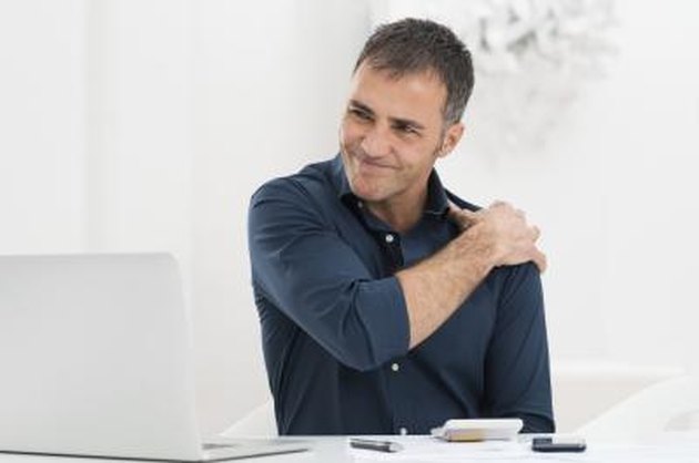 Portrait Of Mature Man At Work Suffering From Shoulder Pain