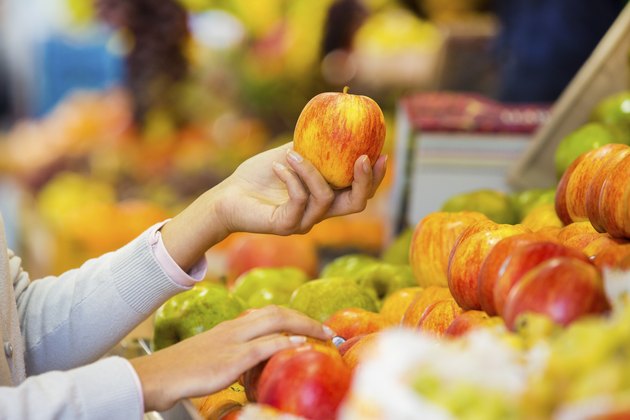 女人在市场上买水果和蔬菜