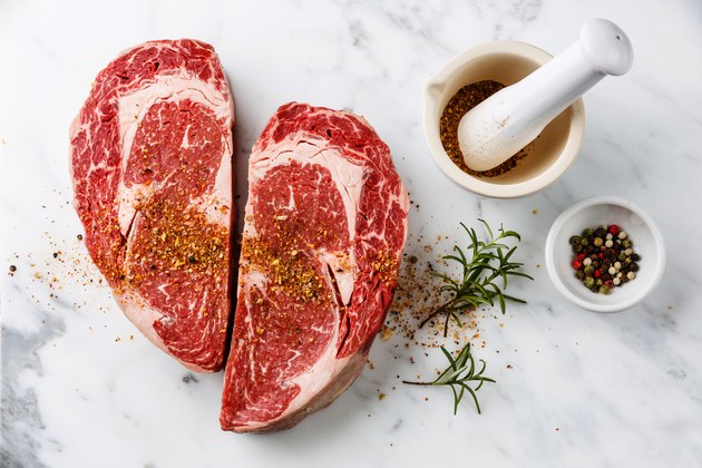 Heart shape Raw meat Ribeye Steak with pepper and rosemary
