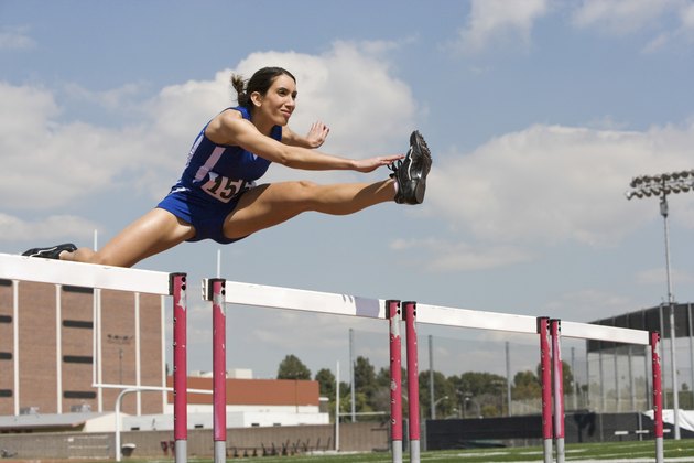 Female Athlete Jumping Over A Hurdles