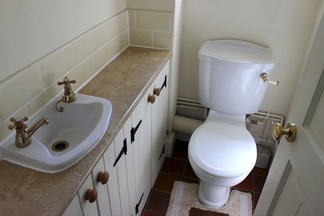 Image of country style cloakroom toilet, basin and storage cupboards