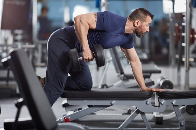 Man doing dumbbell row for back workout in the gym