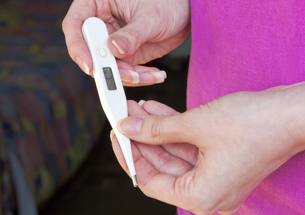 Electronic thermometer holding a woman's hand