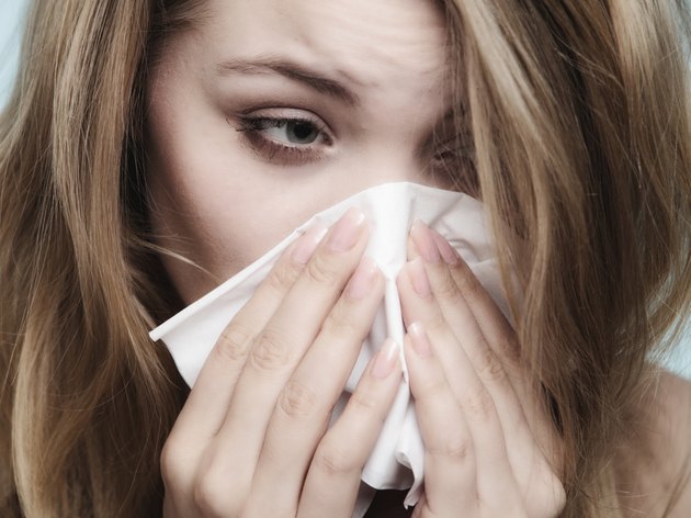 Flu allergy. Sick girl sneezing in tissue. Health