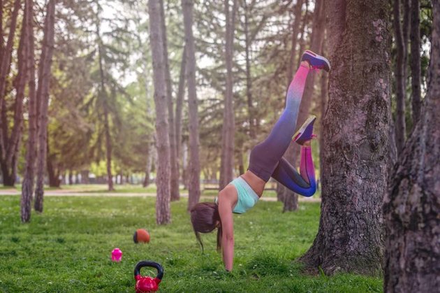 girl is having exercise on a tree , recreation in a park , having props lying on a grass