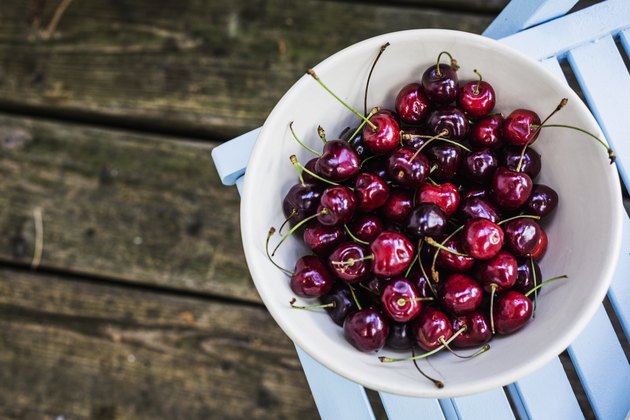 Bowl of cherries on top of patio chair