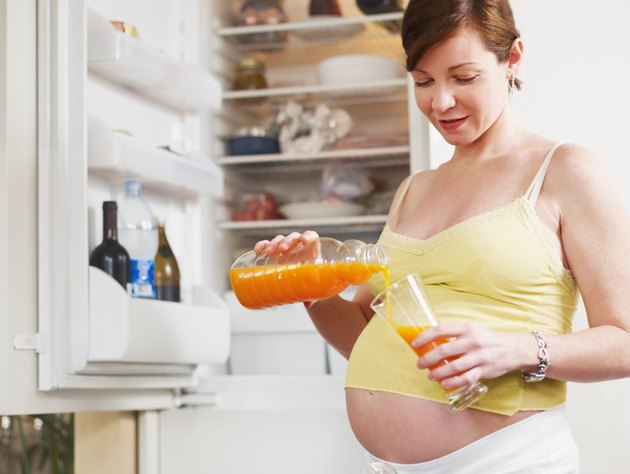 孕妇与橙汁的玻璃杯