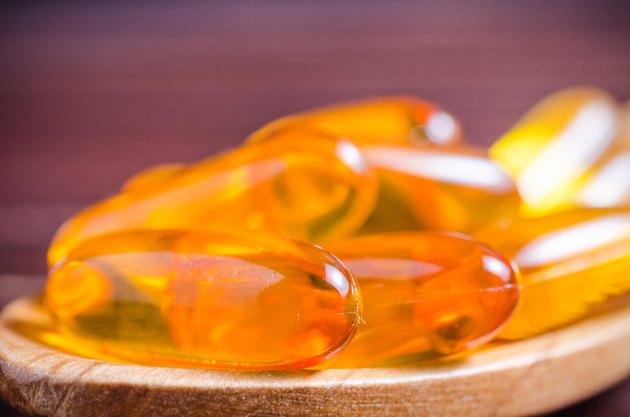 Fish oil on wooden spoon with wooden background
