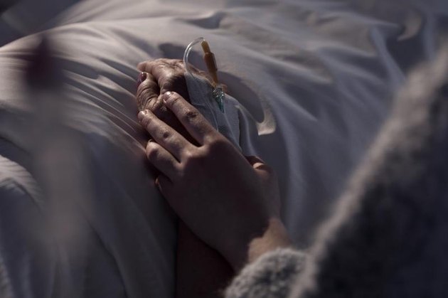 Photo of woman supporting dying mother with cancer.