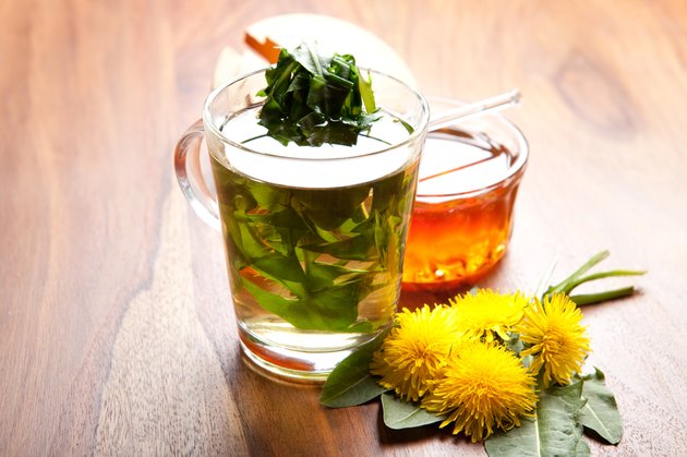 herbal dandelion tea with fresh leaf inside teacup